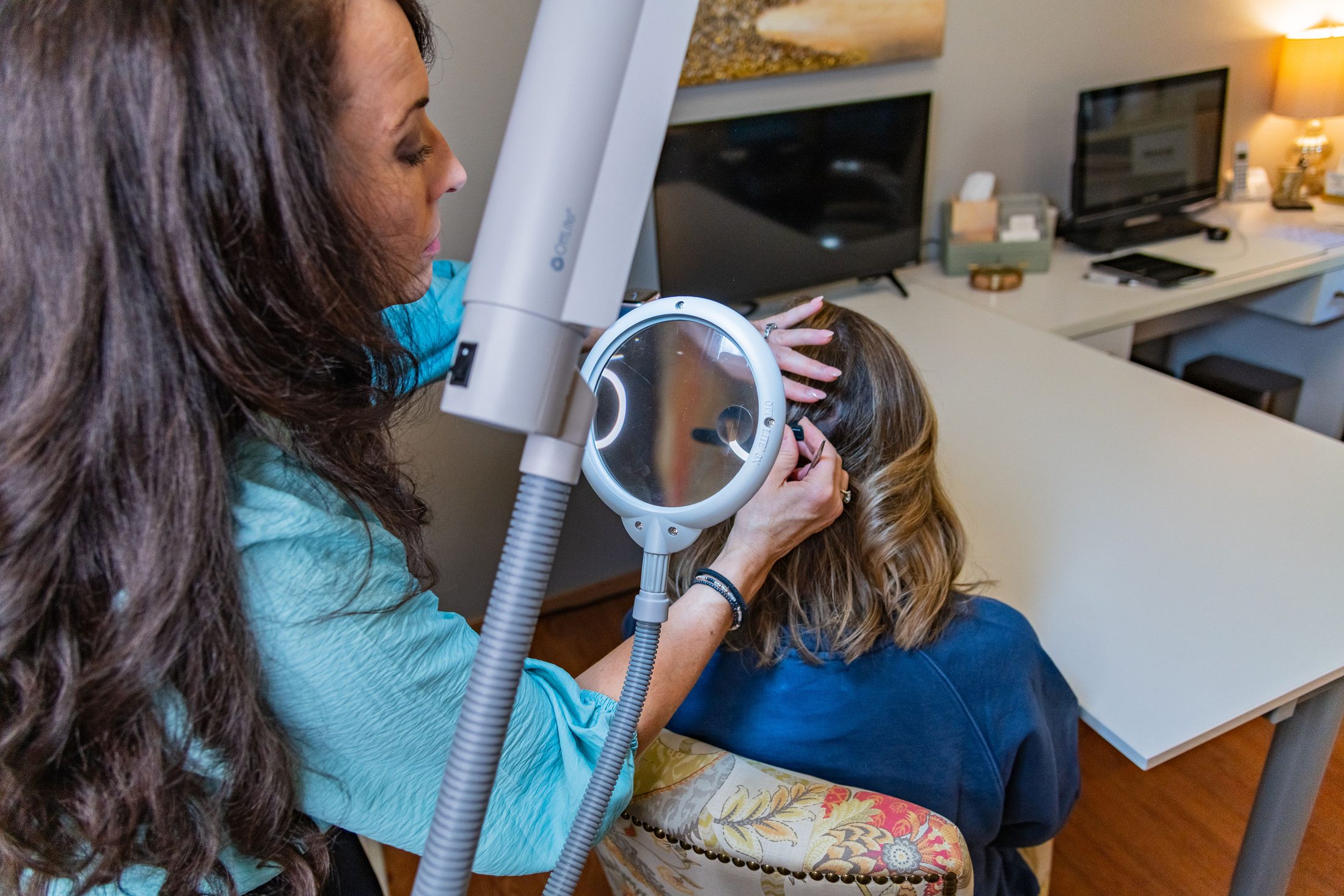Amy Gray taking hair strands at the root from the back of a client&rsquo;s head for an epigenetic hair scan in Fort Collins