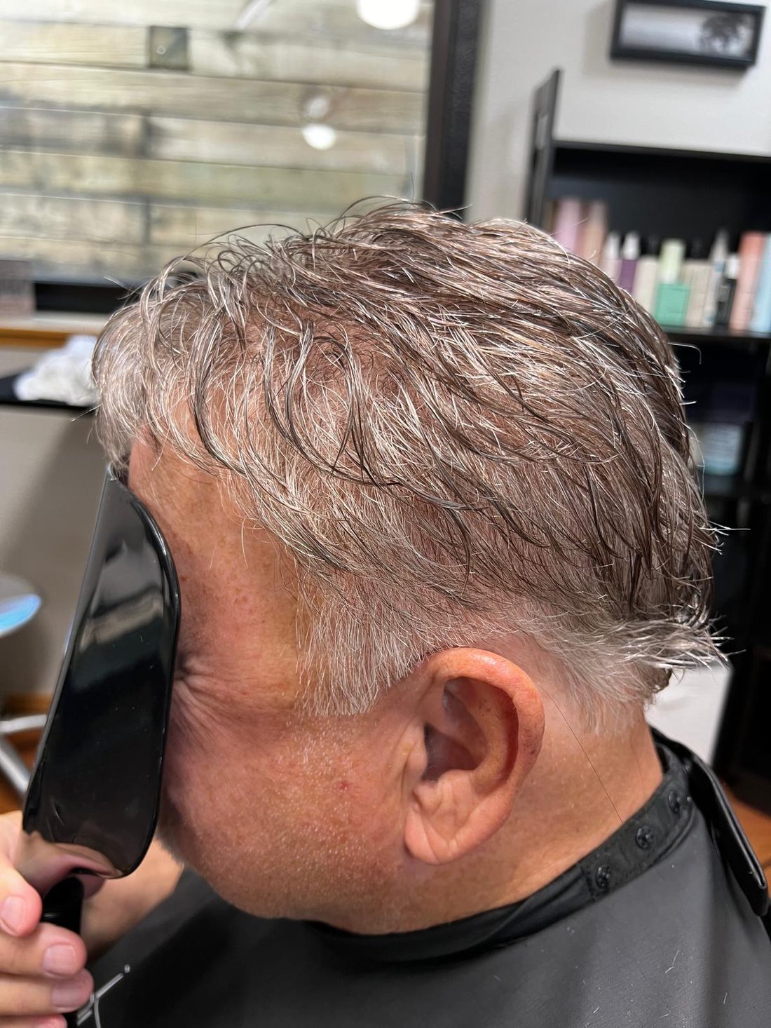 The same side view after a gray hair replacement system was fitted, before styling