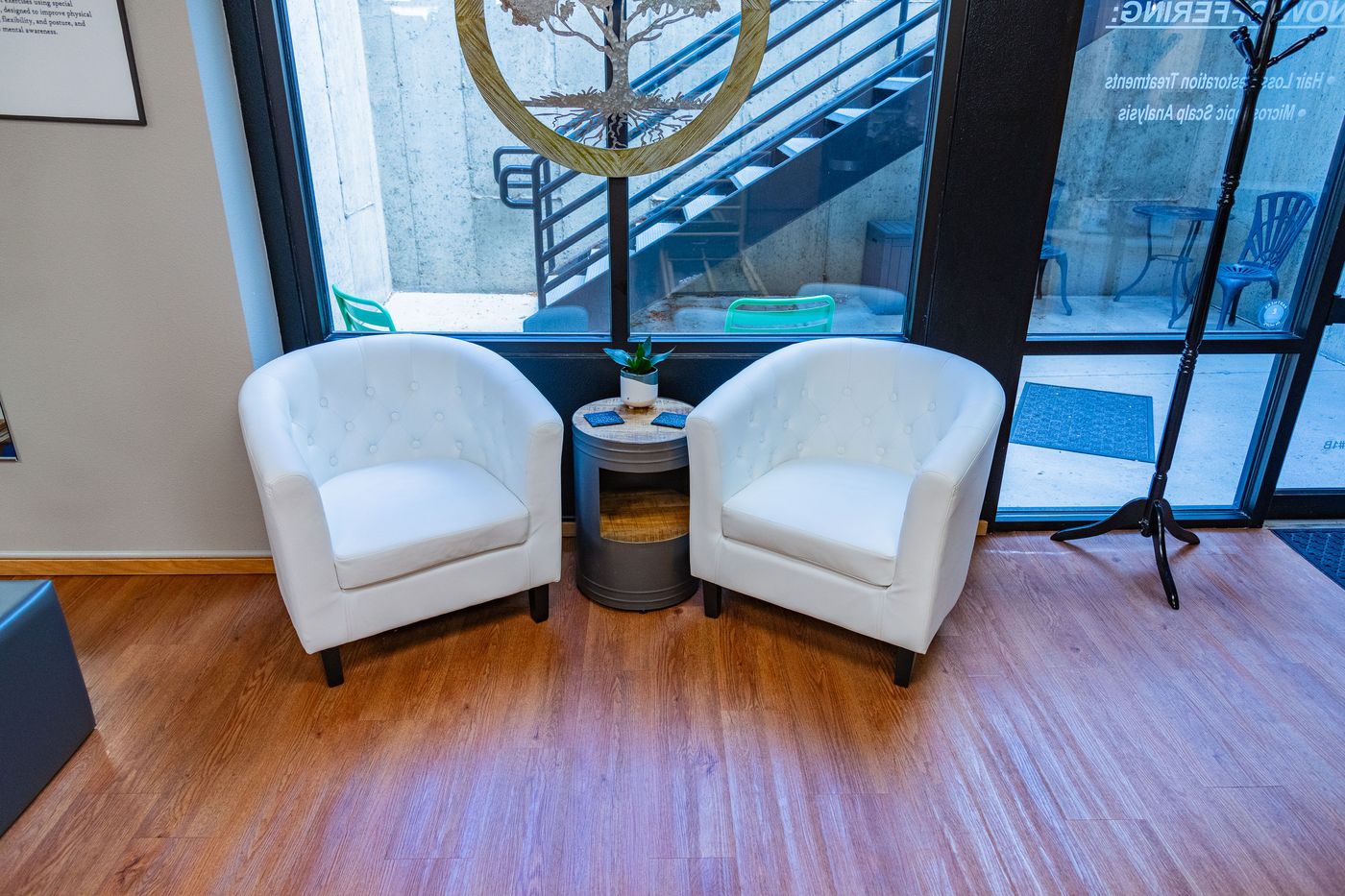 The waiting area at Core & Crown Collective in Fort Collins, with two chairs by the window
